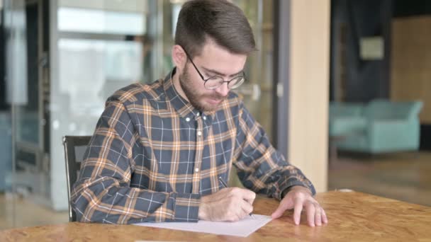 Jovem Designer Focado Escrevendo em Papel no Escritório — Vídeo de Stock