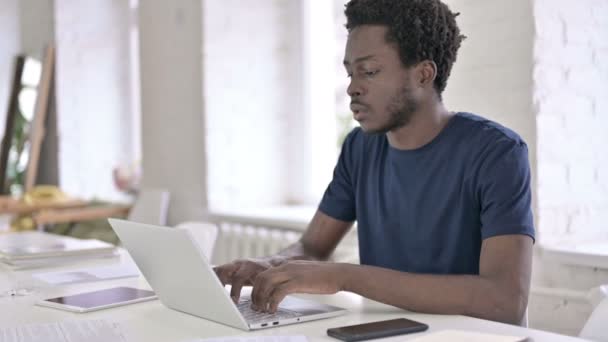 Mladý africký designér pracující na notebooku v Loft Office — Stock video