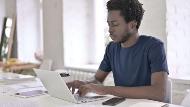 Sonriente joven africano mirando a la cámara en el trabajo — Vídeo de stock