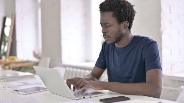 Hardwerkende jonge Afrikaanse ontwerper met mislukking op laptop — Stockvideo