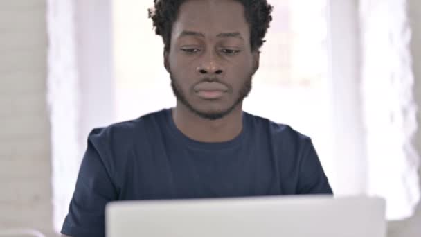 Primer plano de un joven africano trabajando en un ordenador portátil — Vídeo de stock