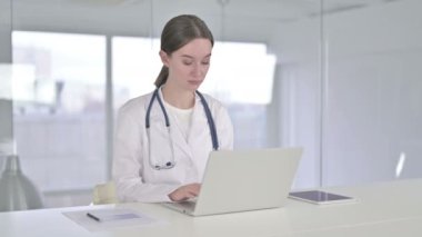 Ofiste dizüstü bilgisayarda çalışan hırslı genç bayan doktor.