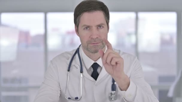Retrato del médico de mediana edad diciendo no con el signo de dedo — Vídeos de Stock
