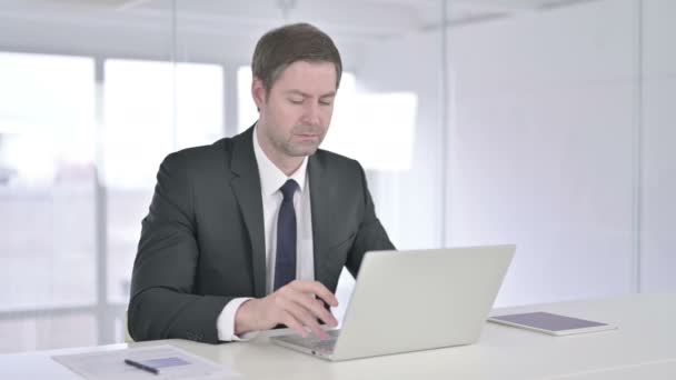 Atractivo hombre de negocios de mediana edad mirando a la cámara y sonriendo — Vídeos de Stock