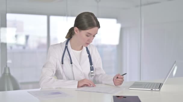 Laboriosa giovane medico femminile lettura documenti in ufficio — Video Stock