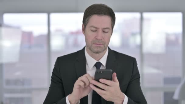 Joyeux Moyen Age Homme d'affaires en utilisant Smartphone dans le bureau — Video