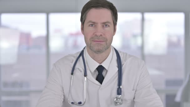 Retrato del sonriente médico de mediana edad mirando a la cámara — Vídeos de Stock