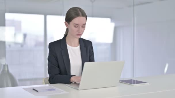 Ambitieuze jonge zakenvrouw werkt op laptop in kantoor — Stockvideo