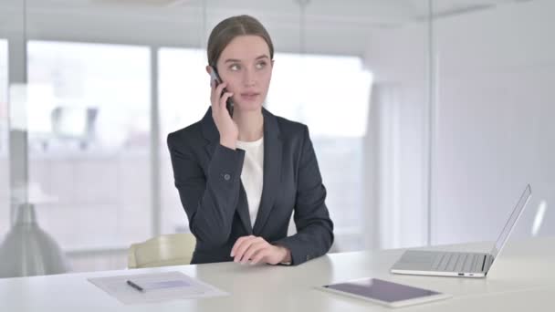 Sorprendida joven empresaria hablando por teléfono inteligente — Vídeo de stock