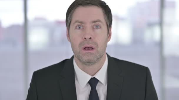 Porträt eines schockierten Geschäftsmannes mittleren Alters, der auf Versagen reagiert — Stockvideo