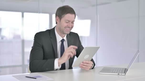 Empresario de mediana edad haciendo Video Chat en Tablet en Office — Vídeo de stock