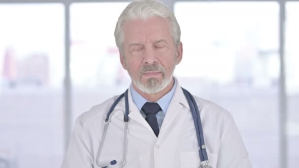 Портрет старшего врача, смотрящего в камеру — стоковое видео