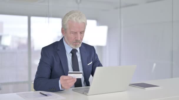 Сосредоточенный бизнесмен среднего возраста, осуществляющий онлайн-платежи на ноутбуке — стоковое видео