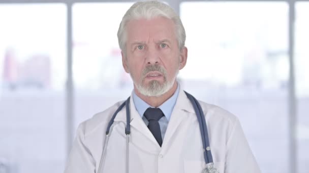 Портрет пожилого врача, делающего видеочат — стоковое видео
