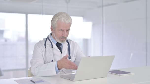 Wesoły starszy lekarz robi czat wideo na laptopie — Wideo stockowe
