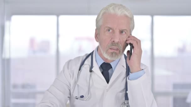 Portrait of Senior Old Doctor Talking on Smartphone in Office — Stock Video