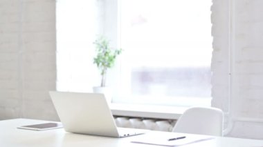 Orta yaşlı profesyonel erkek tasarımcı geliyor ve oturuyor. 