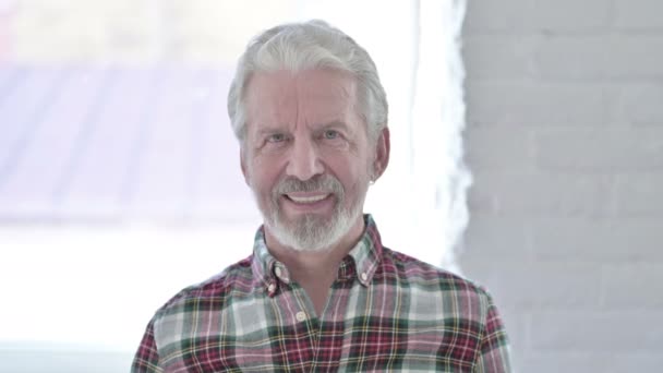 Portret starego męskiego projektanta patrzącego w kamerę i uśmiechającego się — Wideo stockowe