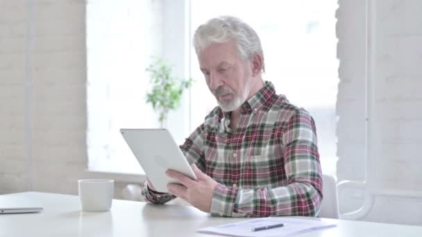 Travailler dur occasionnel vieil homme en utilisant la tablette dans le bureau — Video