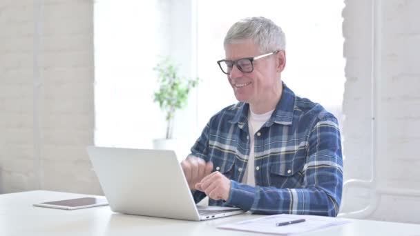 Fröhliche lässige Mann mittleren Alters tun Video-Chat auf Laptop — Stockvideo