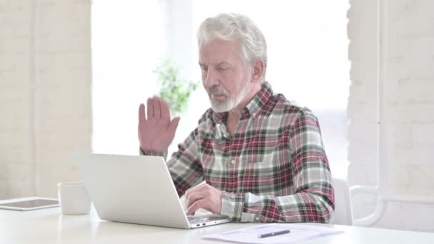 Випадковий старий робить відео чат на ноутбуці в офісі — стокове відео