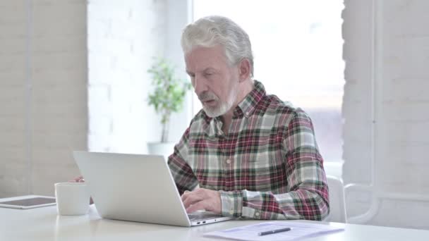 Ahkera rento vanha mies juo kahvia ja työskentelee — kuvapankkivideo