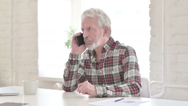 Wściekły, przypadkowy staruszek rozmawiający na smartfonie — Wideo stockowe