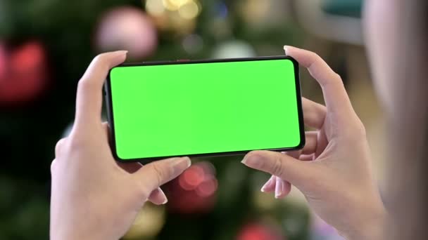 Κρατώντας οριζόντια Chroma βασική οθόνη Smartphone κοντά Χριστούγεννα Διακόσμηση — Αρχείο Βίντεο