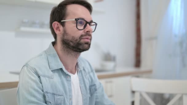 Sérieux barbe jeune homme regardant caméra dans bureau — Video