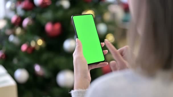 Femeie care utilizează smartphone-ul Green Mock-up Screen lângă decorațiunile de Crăciun — Videoclip de stoc