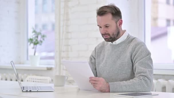 Homme excité célébrant le contrat, lecture de documents — Video