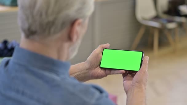 Vecchio che guarda video sullo smartphone verde finto schermo — Video Stock