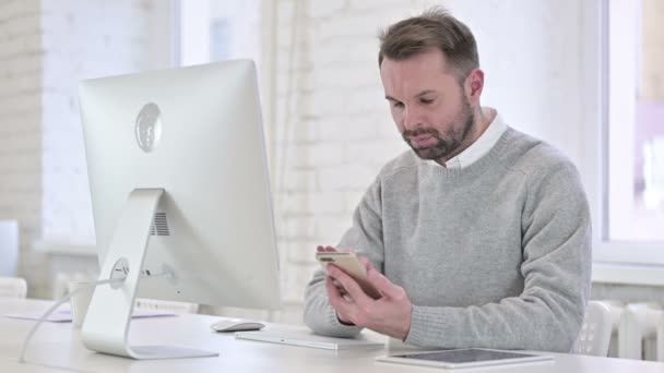 Hombre creativo trabajando en la computadora y el uso de Smartphone — Vídeos de Stock