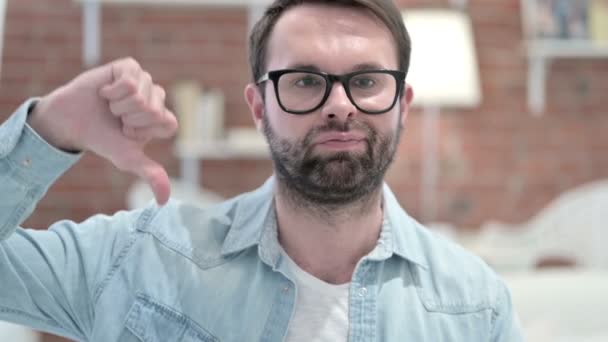 Porträt eines unglücklichen jungen Mannes mit Bart, der Daumen nach unten zeigt — Stockvideo