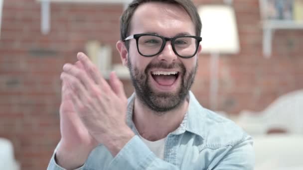 Porträt eines fröhlichen jungen Mannes mit Bart, der klatscht und lächelt — Stockvideo