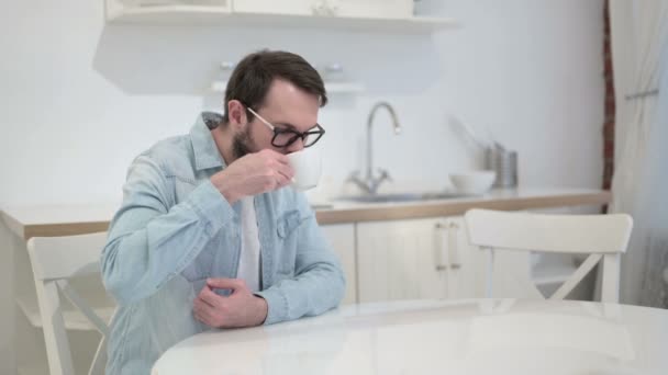 사무실에서 차가운 음료를 마심으로써 치통을 앓고 있는 수염을 가진 청년 — 비디오