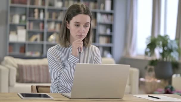 Mulher jovem Pensando e trabalhando no laptop no escritório — Vídeo de Stock