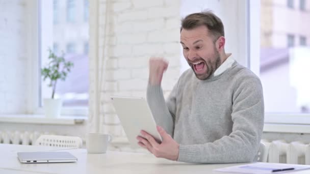 Hombre creativo celebrando el éxito en línea en la tableta — Vídeos de Stock