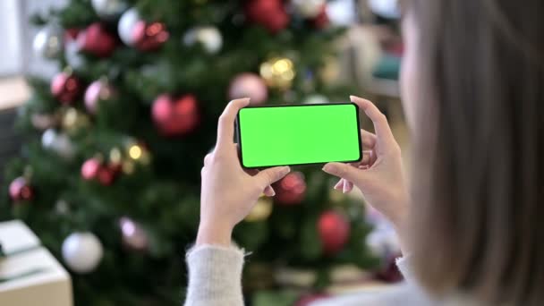 Mujer celebración de croma pantalla clave Smartphone cerca del árbol de Navidad — Vídeos de Stock