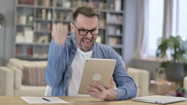 Emocionado joven diseñador celebrando el éxito en la tableta en Loft Office — Vídeos de Stock