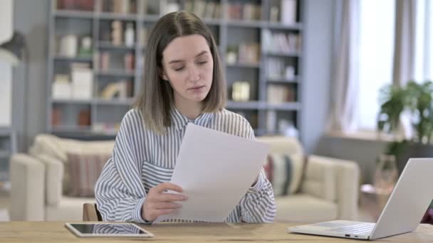 Молодая женщина думает и пишет на бумаге в офисе — стоковое видео