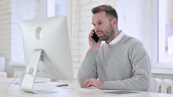 Creative Man Talking on Smartphone at Work — Stock video