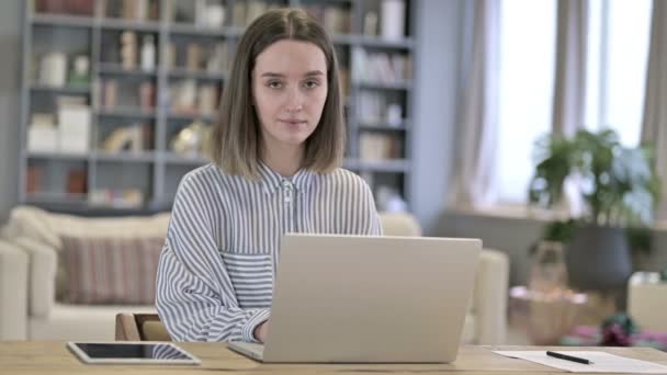 Mosolygó fiatal nő néz a kamera az irodában — Stock videók