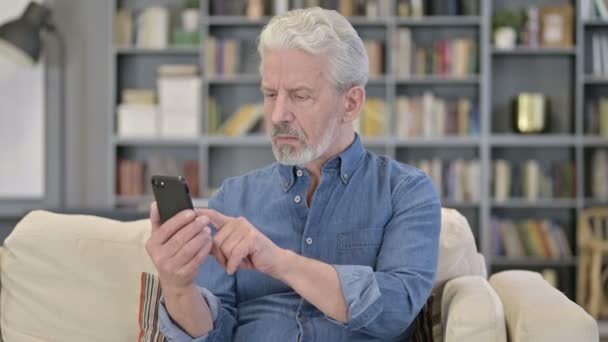 Porträtt av äldre gubbe som reagerar på misslyckande på smartphone — Stockvideo