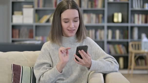 Portret van jonge vrouw reageert op verlies op smartphone — Stockvideo