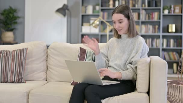 Veselá mladá žena dělá video chat na notebooku na pohovce — Stock video