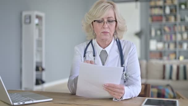 Profissional de idade feminino médico leitura documentos — Vídeo de Stock