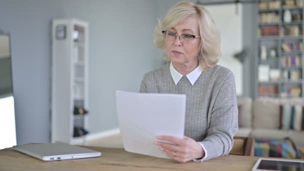 Mulher velha bonita fazendo trabalho de papel no escritório moderno — Vídeo de Stock
