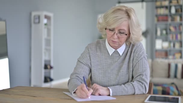 Серьезные документы для чтения пожилых женщин в современном офисе — стоковое видео