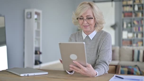 Старуха с помощью планшета в современном офисе — стоковое видео